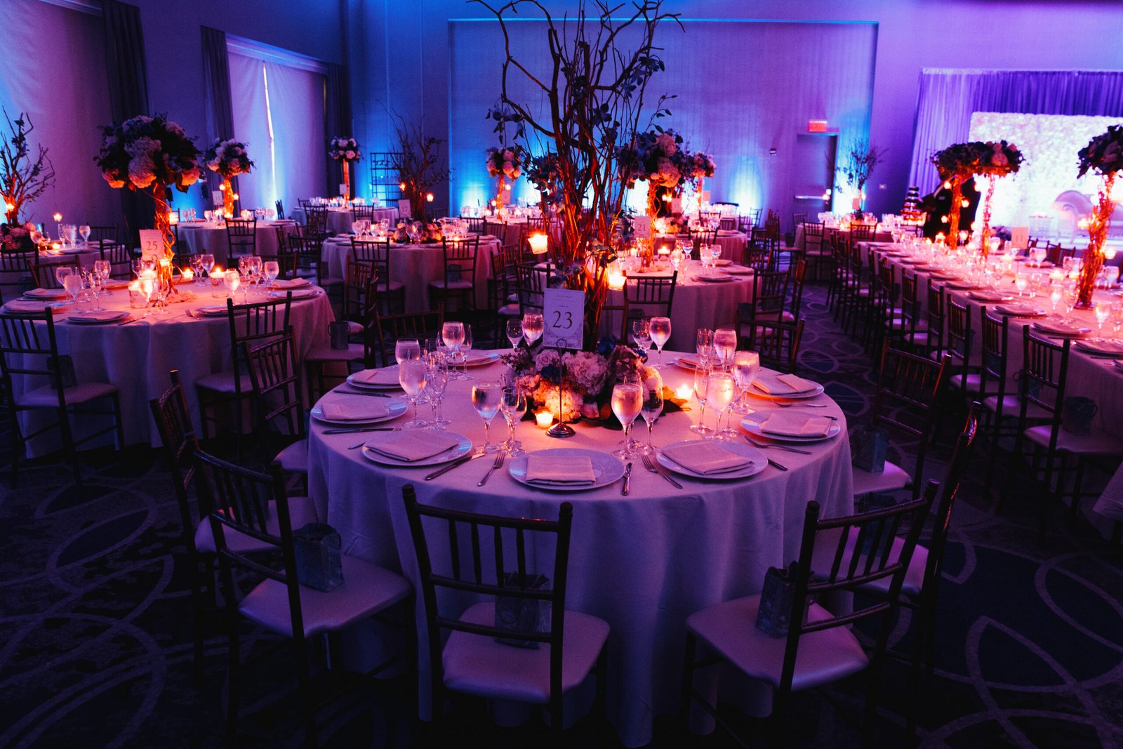Decorated wedding hall with candles, round tables and centerpiec